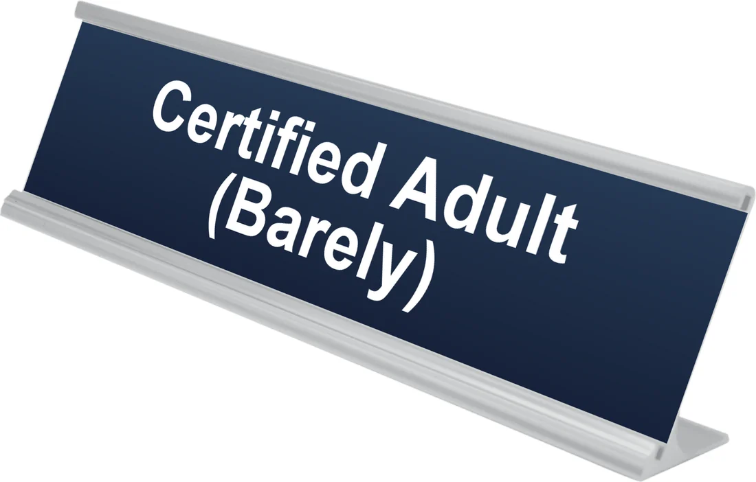 Certified Adult (Barely) desk plate in navy, shown in an aluminum desk holder