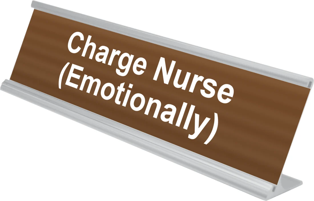 Charge Nurse (Emotionally) desk plate in walnut, shown in an aluminum desk holder