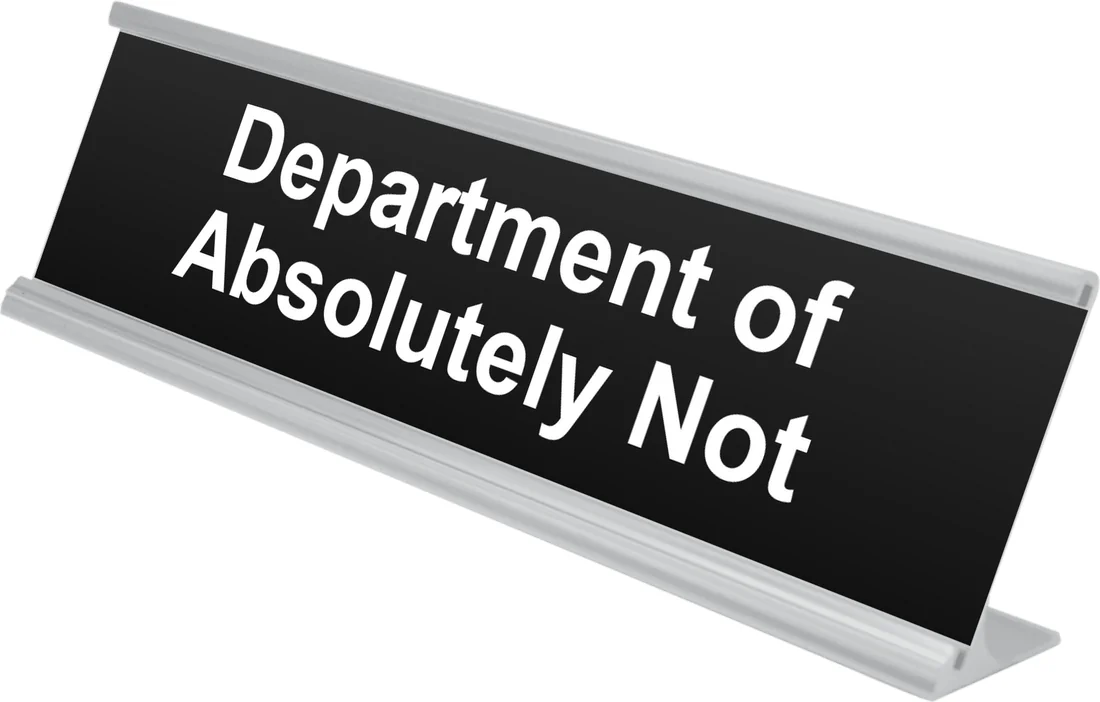 Department of Absolutely Not desk plate in black, shown in an aluminum desk holder