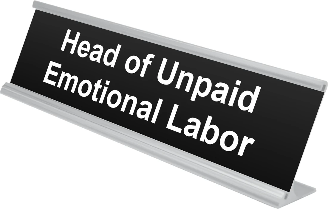 Head of Unpaid Emotional Labor desk plate in black, shown in an aluminum desk holder