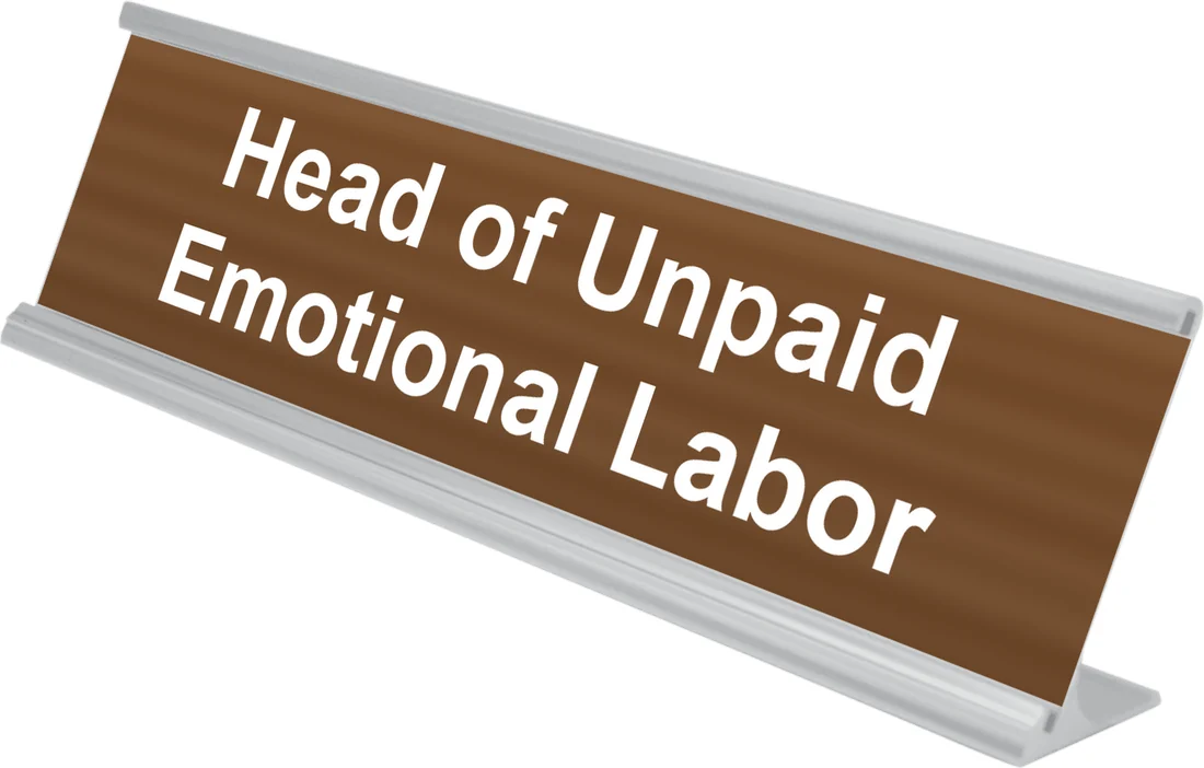 Head of Unpaid Emotional Labor desk plate in walnut, shown in an aluminum desk holder