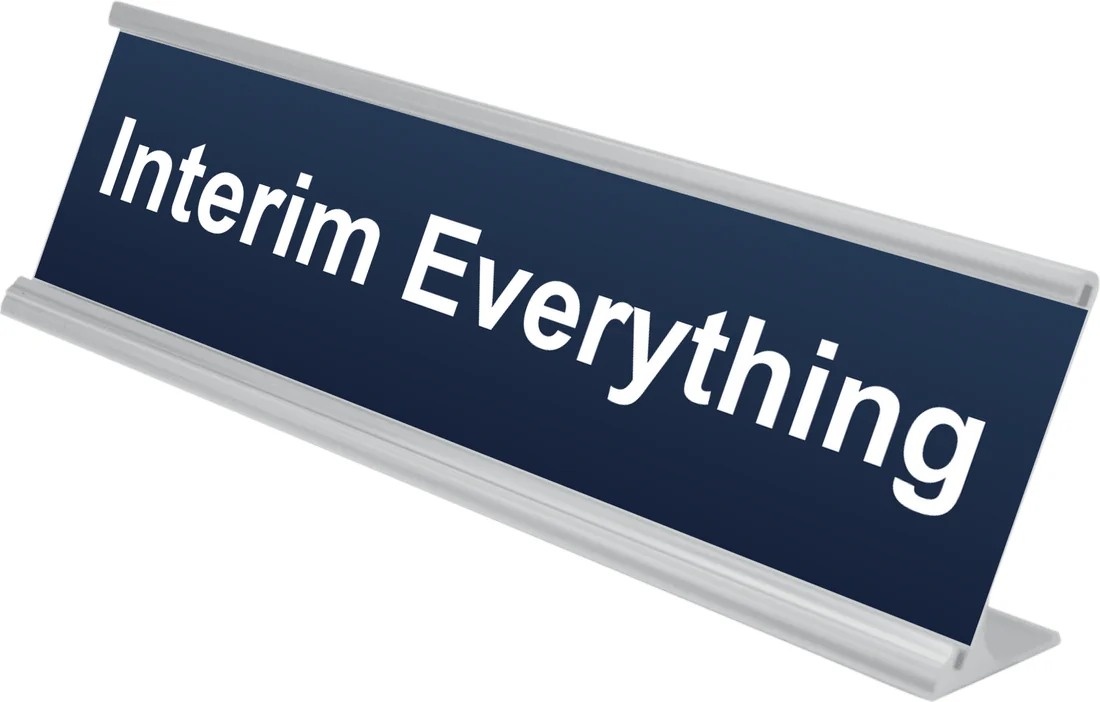 Interim Everything desk plate in navy, shown in an aluminum desk holder