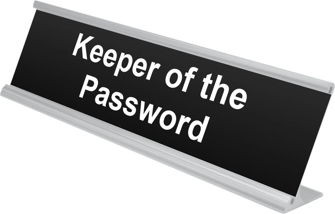 Keeper of the Password desk plate in black, shown in an aluminum desk holder