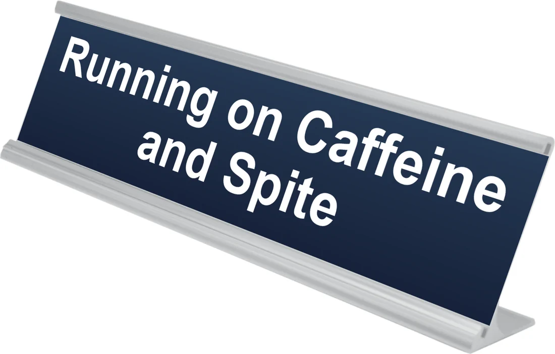 Running on Caffeine and Spite desk plate in navy, shown in an aluminum desk holder