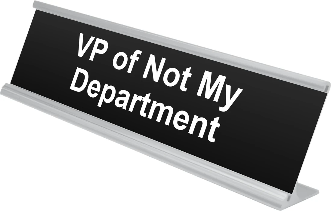 VP of Not My Department desk plate in black, shown in an aluminum desk holder